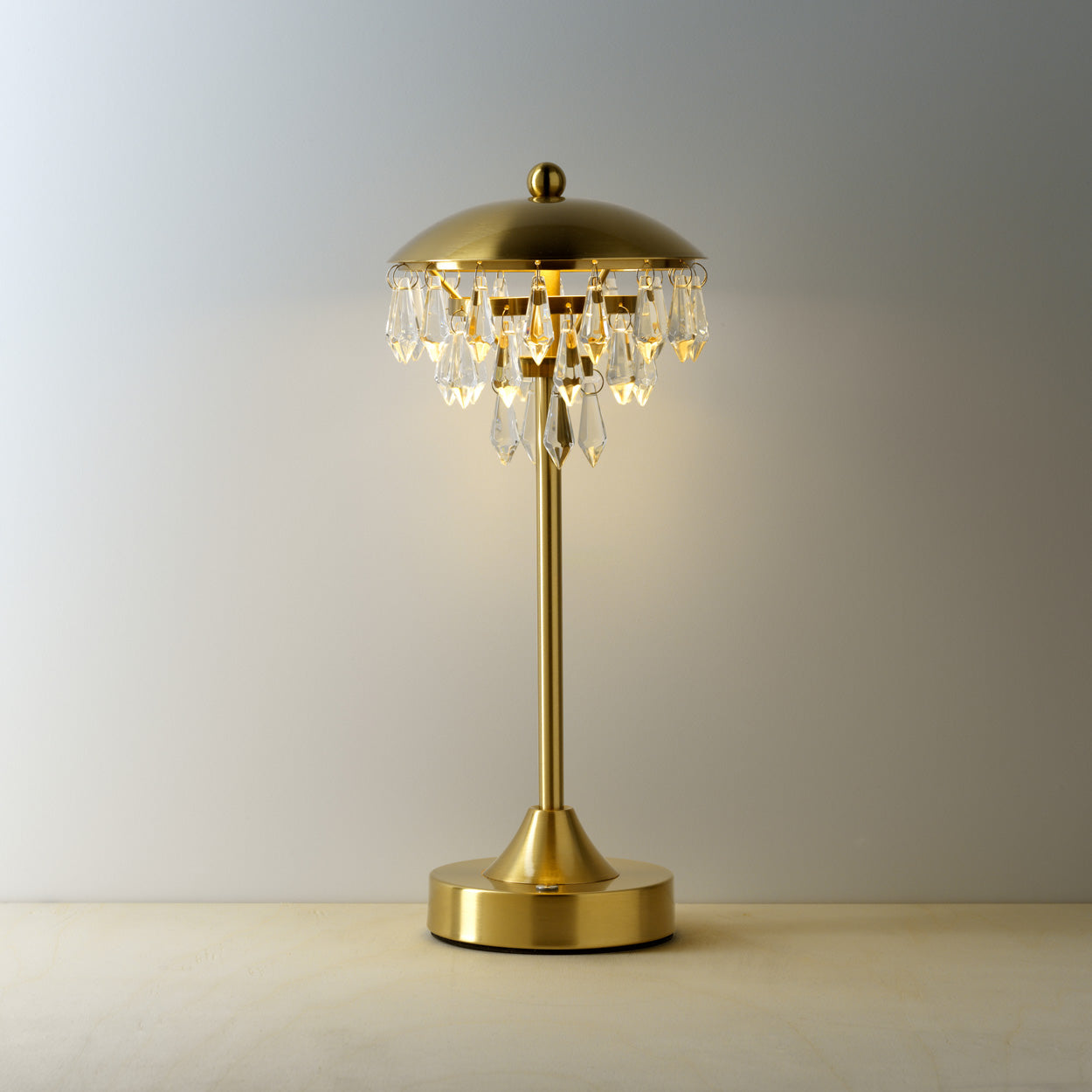Gold table lamp with crystal accents on a warm background