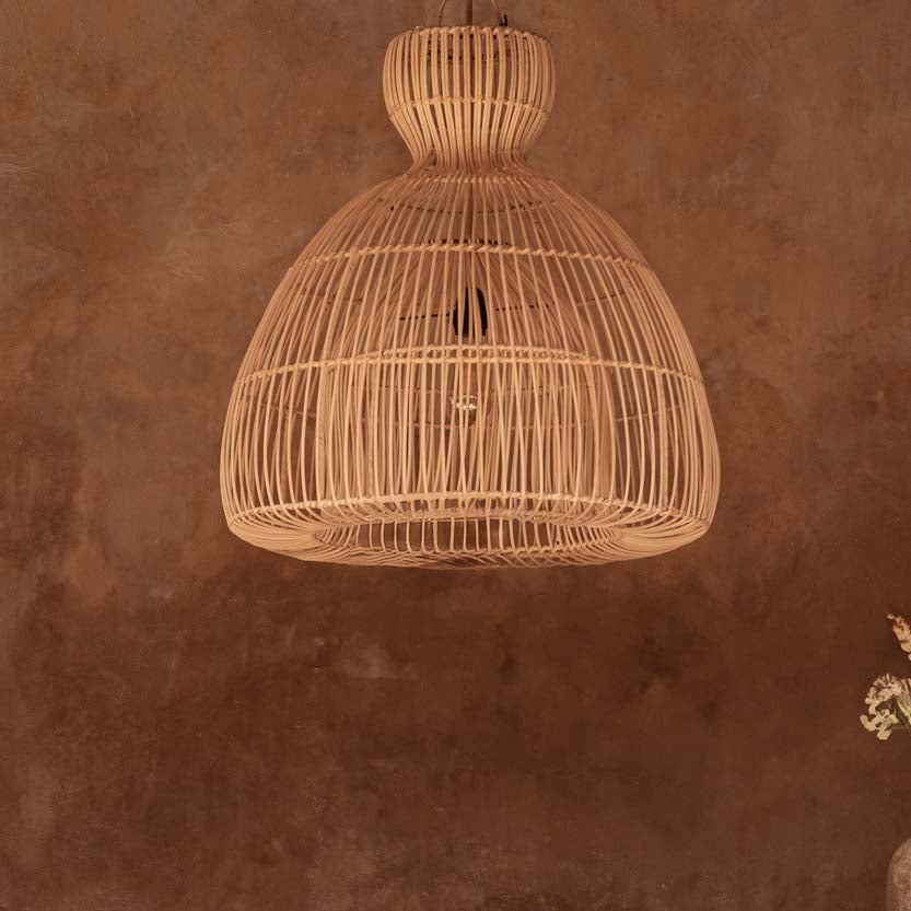 Woven pendant light hanging above a wooden table with a brown wall background