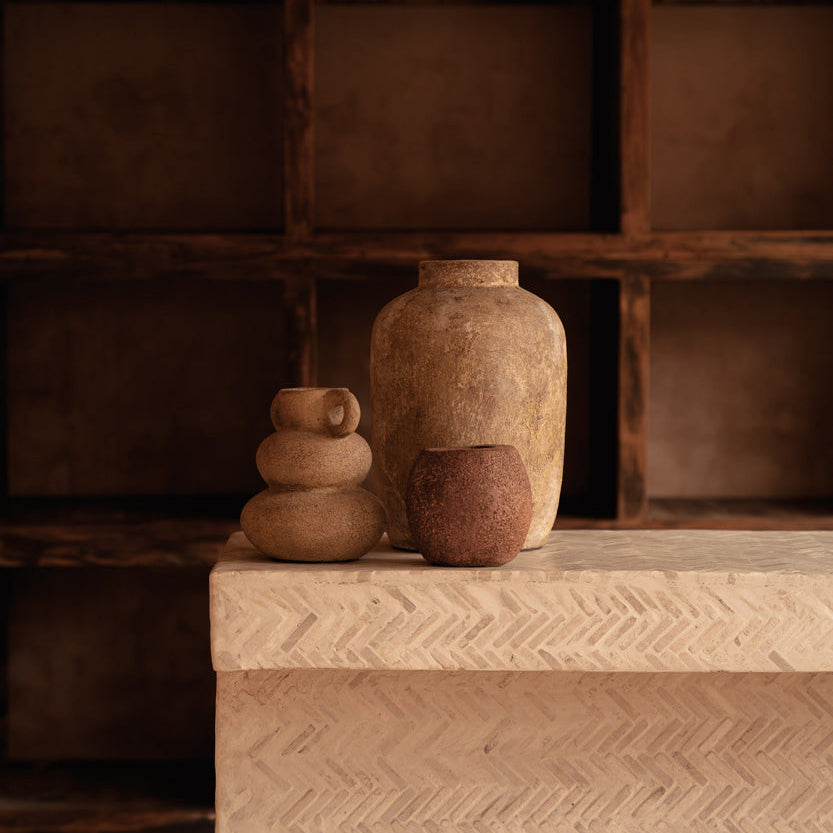Three rustic vases on a textured surface