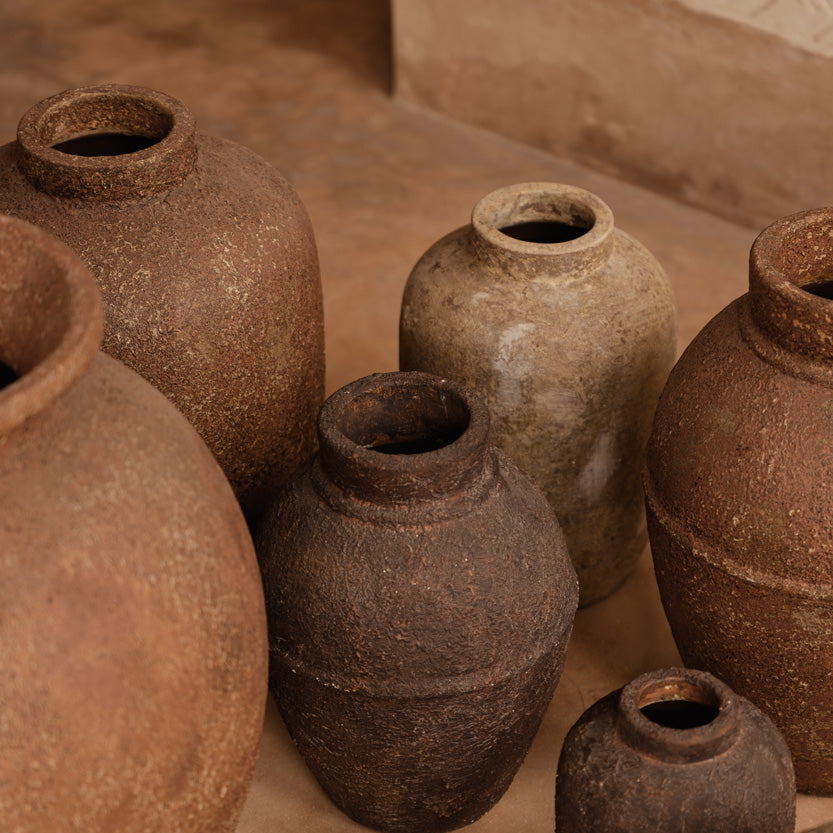 Collection of terracotta vases on a stone surface