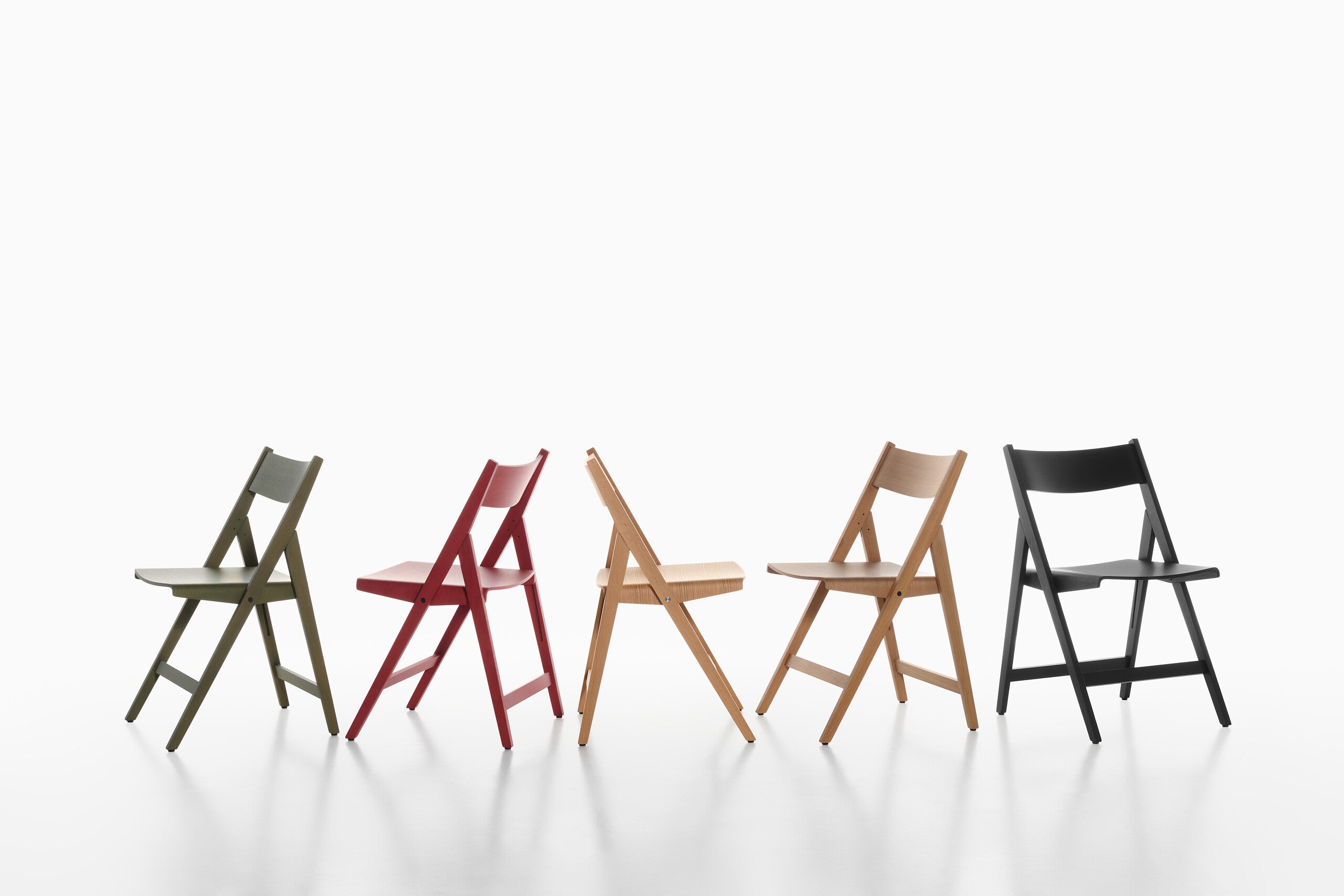 Five THEO folding chairs in different colors arranged in a row on a white background