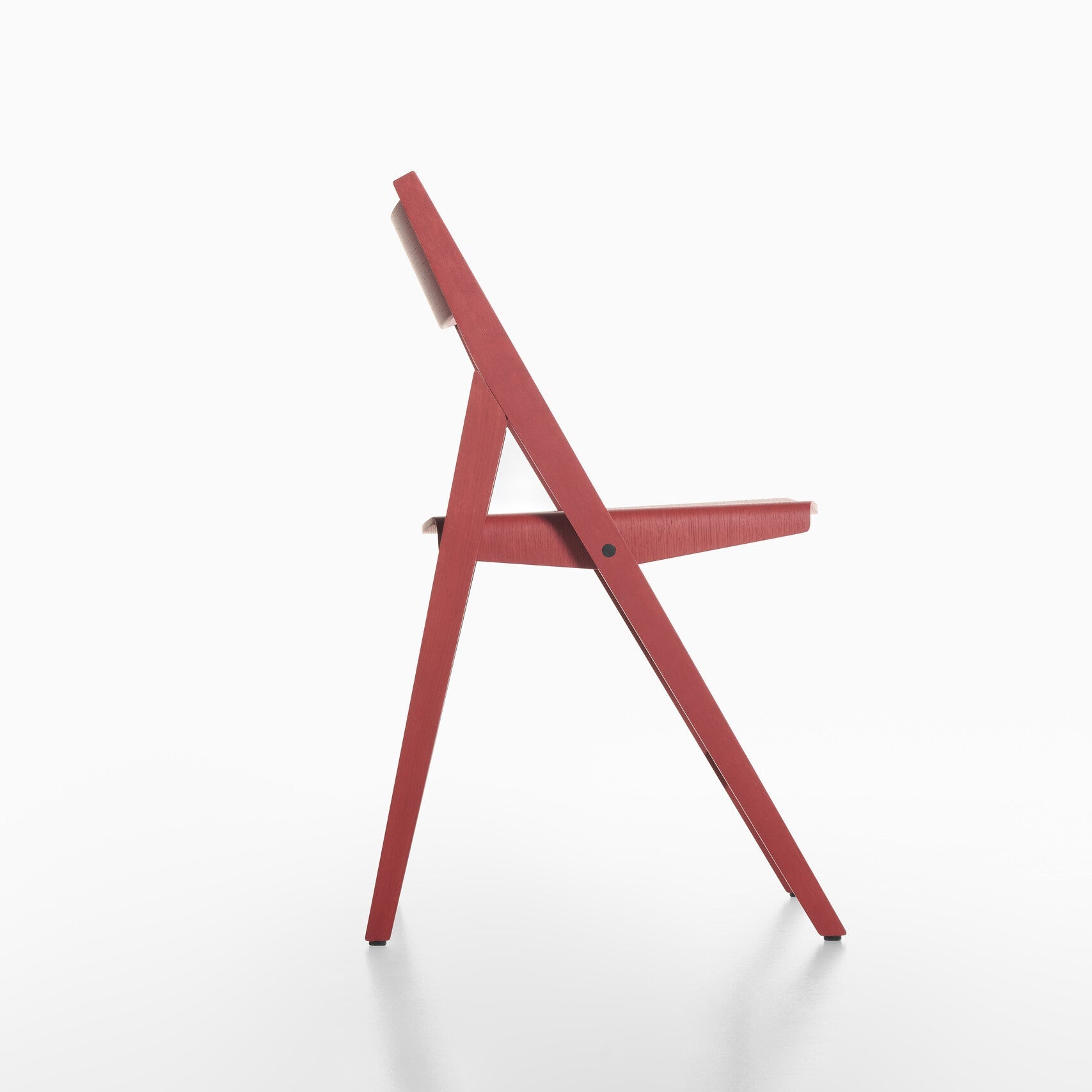 Side view of red THEO folding chair on a white background